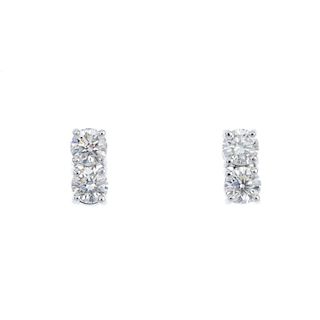 A pair of 18ct gold diamond earrings. Each designed as two brilliant-cut diamonds, to the fixed post