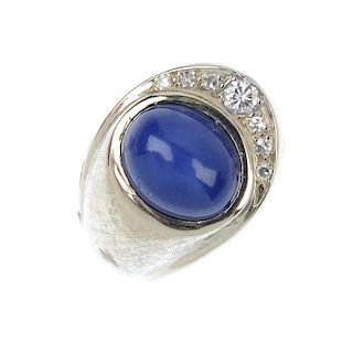 A 14ct gold synthetic star sapphire and diamond dress ring. The oval synthetic star sapphire cabocho