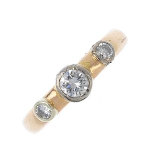 A 9ct gold diamond three-stone ring. The raised brilliant-cut diamond collets, to the plain band. Es