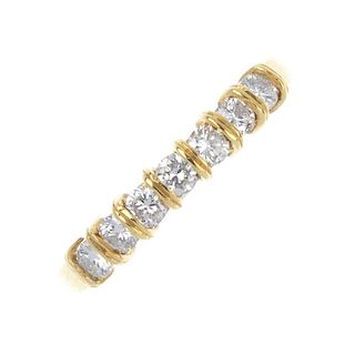 An 18ct gold diamond half-circle eternity ring. The brilliant-cut diamond line, with grooved spacers