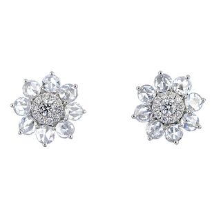 * A pair of diamond floral cluster ear studs. Each designed as a brilliant-cut diamond cluster, with