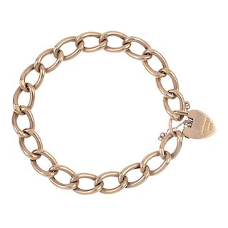 An Edwardian 9ct gold curb-link bracelet. The elongated curb-links, to the padlock clasp. Clasp with