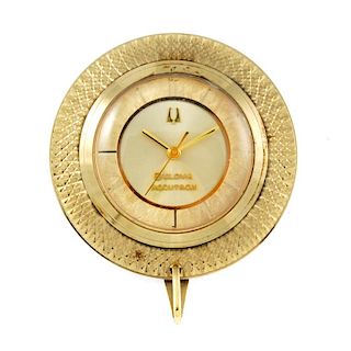An Accutron desk clock which can convert into a pendent by Bulova. Gold plated case with desk stand.
