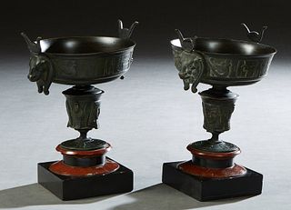 Pair of Egyptian Revival Bronze Urn Garnitures, early 20th c., with relief hieroglyphic sides, on a relief decorated socle, to a rouge marble plinth o