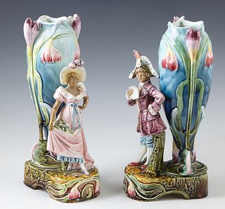 Pair of Continental Late Victorian Figural Vases, c. 1900, with standing figures of a man and woman in 18th c. dress, in front of a tall relief floral