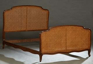 French Carved Walnut Louis XV Style Double Bed, early 20th c., the arched double caned headboard, to scalloped rails and a like double caned footboard