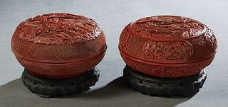 Two Chinese Circular Cinnabar Covered Boxes, 20th c., with relief figural and scenic decoration, on wooden stands, Boxes- H.- 4 in., Dia.- 7 1/8 in. P