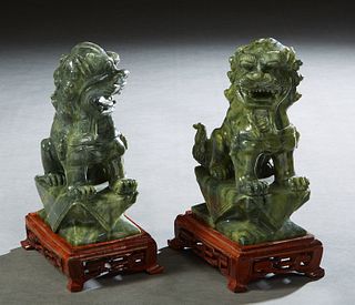 Pair of Chinese Carved Dark Green Jade Foo Lions, 20th c., on custom carved mahogany stands, Figures- H.- 7in., W.- 2 1/2 in., D.- 4 in. Provenance: P