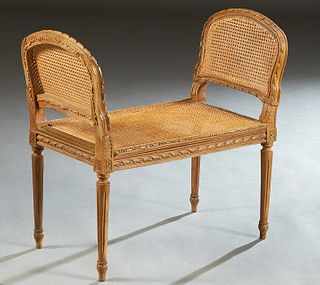 French Carved Walnut Louis XVI Style Bench, early 20th c., the canted arched sides over a caned seat, on turned tapered reeded legs, H.- 28 3/4 in., W