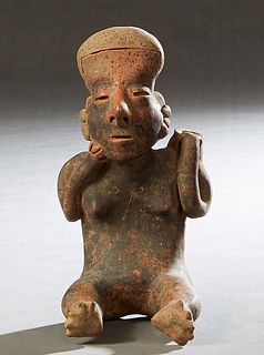 Pre-Columbian Pottery Figure of a seated man with a jar on his back, H.- 9 3/4 in., W.- 5 in., D.- 5 3/4 in. Provenance: Palmira, the Estate of Sarkis