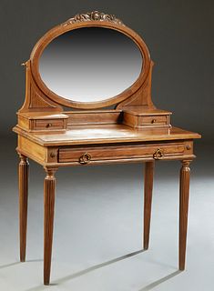 French Louis XVI Style Carved Walnut Dressing Table, 20th c., the oval swiveling beveled glass mirror with a floral carved top, over two small drawers