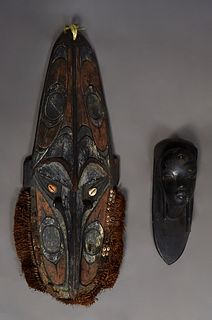Two African Carved Figures, 20th c., one a tall mask with "hair" and cowry shell decoration, the other of ebony with a high relief female bust, Mask- 
