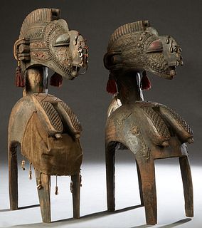 Pair of African Carved Wood Figures, 20th c., of animals, clad in sheet iron with cowrie shell decoration, Larger- H.- 28 1/4 in., W.- 6 1/2 in., D.- 