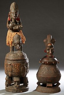 Two Unusual African Carved Wooden Covered Jars, 20th c., one with a female bust handle, the whole mounted with red beads and cowrie shells; the second