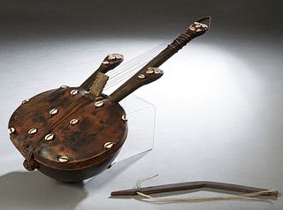 West African Kora Musical Instrument, made of a leather covered gourd, with 8 strings and cowrie shell decoration, H.- 30 1/2 in., W.- 12 in., D.- 5 1