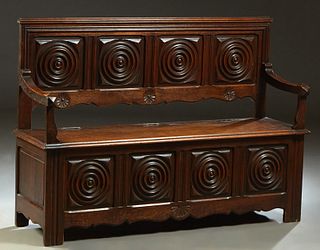 French Provincial Henri II Style Carved Oak Settee, late 19th c., the stepped crown with four concentric circle carved panels, over curved arms flanki