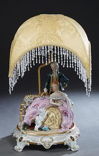 Porcelain Meissen Style Figural Lamp, 20th c., with a couple in 19th c. dress and a cat, on a gilt decorated circular base, with a silk shade hung wit