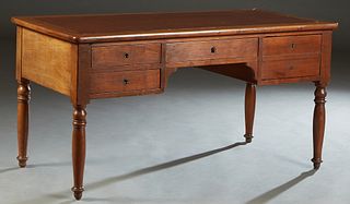 French Louis Philippe Style Carved Cherry Desk, early 20th c., the rounded corner top with an inset leather writing surface over a center frieze drawe