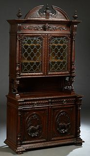 French Carved Oak Henri II Style Buffet a Deux Corps, c. 1880, the arched breakfront crest over a stepped finial crown above setback double cupboard l