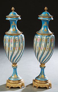 Pair of Sevres Style Gilt Spelter Mounted Covered Garniture Vases, 19th c., of tapered form in heavenly blue with gilt decoration, the sides with swir