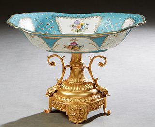 French Style Porcelain Centerpiece, 20th/21st c., the pierced open celestial blue bowl with a painted reserve of flowers, on a bright brass socle supp