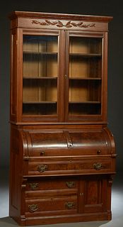 American Carved Walnut Cylinder Secretary Bookcase, late 19th c., the dentillated crown over double glazed doors, flanked by reeded pilasters, over a 