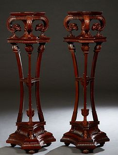 Pair of Georgian Style Carved Mahogany Tall Pedestals, 20th/21st c., the shaped triangular top on rams' head supports, to a triangular plinth, on thre