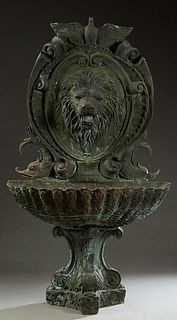 Large Patinated Bronze Wall Fountain, 20th c., with an eagle surmount over a large relief lion's head, above a shell form basin, on scrolled tripodal 