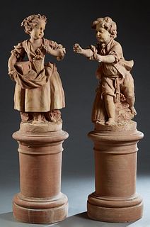 Pair of Large Terracotta Figures, 20th c., of a boy and a girl grape pickers, both in 19th c. dress, on integral circular bases, on stepped cylindrica