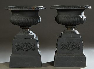 Pair of Cast Iron Campana Form Jardinieres, 20th/21st c., the relief everted rim over a baluster ribbed support to a socle support on an integral base