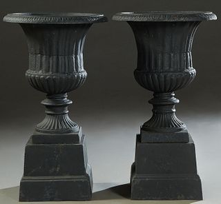 Pair of Cast Iron Campana Form Garden Urns, 20th/21st c., with everted relief decorated rims over tapered ribbed sides, to a socle support, to a squar