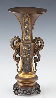 Unusual Gilt and Patinated Bronze Relief Decorated Trumpet Vase, 19th c., with a central square knop flanked by two relief dragons, on a stepped circu