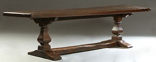 French Provincial Carved Oak Monastery Table, 19th c., the thick two board top on square tapered urn supports, to trestle bases, joined by a large rec