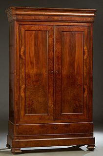 French Louis Philippe Carved Walnut Armoire, c. 1860, the stepped ogee canted crown over double paneled doors over a deep bottom drawer, on a canted c