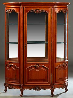 Louis XV Style Carved Cherry Curved Glass Vitrine, 20th c., the stepped ogee top over a setback center glazed door, flanked by curved glass sides over