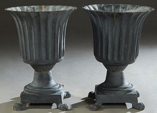 Pair of Cast Iron Campana Form Garden Urns, 20th/21st c., with tapered ribbed sides, on socle supports to square bases, on paw feet, H.- 19 1/2 in., D