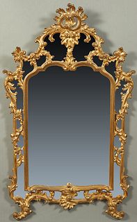 French Gilt and Gesso Louis XIV Style Overmantel Mirror, 19th c., with a pierced arched leaf form crest over a frame of pierced leaf and floral scroll