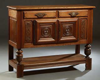 Spanish Renaissance Style Carved Oak Sideboard, early 20th c., the canted edge rectangular top over two frieze drawers above central cupboard doors wi