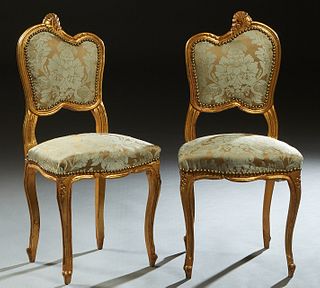 Pair of Louis XV Style Gilt Side Chairs, c. 1900, the shell topped serpentine crest rail over an upholstered back and upholstered bowed seat, on cabri