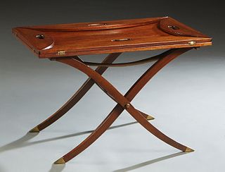 English Carved Mahogany and Brass Folding Butler's Tray Table, 20th c., the four folding sides with hand holes, on an X-form folding stand with brass 