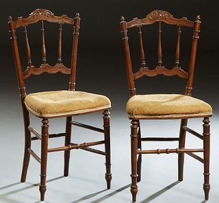 Pair of French Carved Walnut Bedroom Chairs, late 19th c., the arched scroll caned crest rail over a canted spindled back to a trapezoidal cushioned s