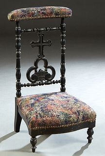 French Louis Philippe Style Ebonized Beech Prie Dieu, c. 1870, the curved padded armrest over a cruciform and trefoil back splat, flanked by turned ta