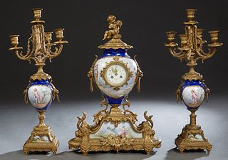 French Three Piece "Sevres" Style Clock Set, early 20th c., the cobalt blue "Sevres" porcelain urn with gilt metal mounts. with a musical putto over a