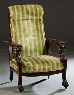 Carved Oak Morris Reclining Chair, c. 1890, the adjustable padded rectangular back flanked by winged gryphon flat arms, to a bowed seat, on paw feet, 