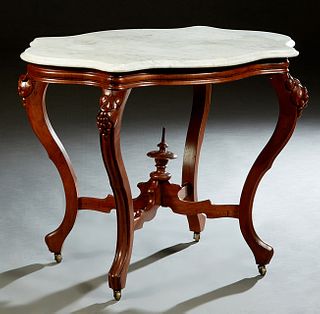 American Carved Walnut Marble Top Center Table, early 20th c., the ogee edge white tortoise marble over a reeded skirt, on grape and leaf carved cabri