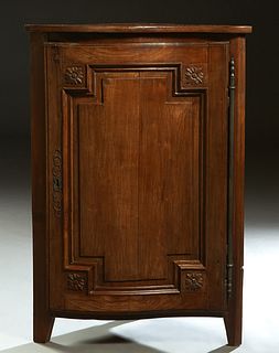 French Louis XV Style Carved Walnut Corner Cabinet, 19th c., the serpentine top over a convex floral carved fielded panel door with a long steel fiche