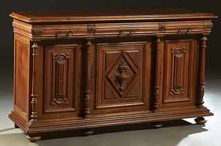 French Henri II Style Carved Walnut Sideboard, c. 1880, the stepped rounded edge top over three frieze drawers, above three setback incised fielded pa