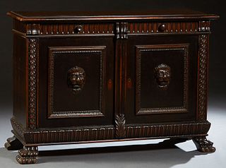 Continental Carved Mahogany Sideboard, late 19th c., the stepped rectangular top over two frieze drawers above setback double cupboard doors, with lio