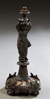 Cast Iron Figural Garden Statue, of a putto, on a reeded socle support to a reeded circular base on four feet, H.- 23 1/4 in., Dia.- 11 1/2 in. Proven