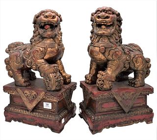 Pair of Carved Wood Foo Dogs, in gilt red paint, height 20 inches, width 11 1/2 inches.